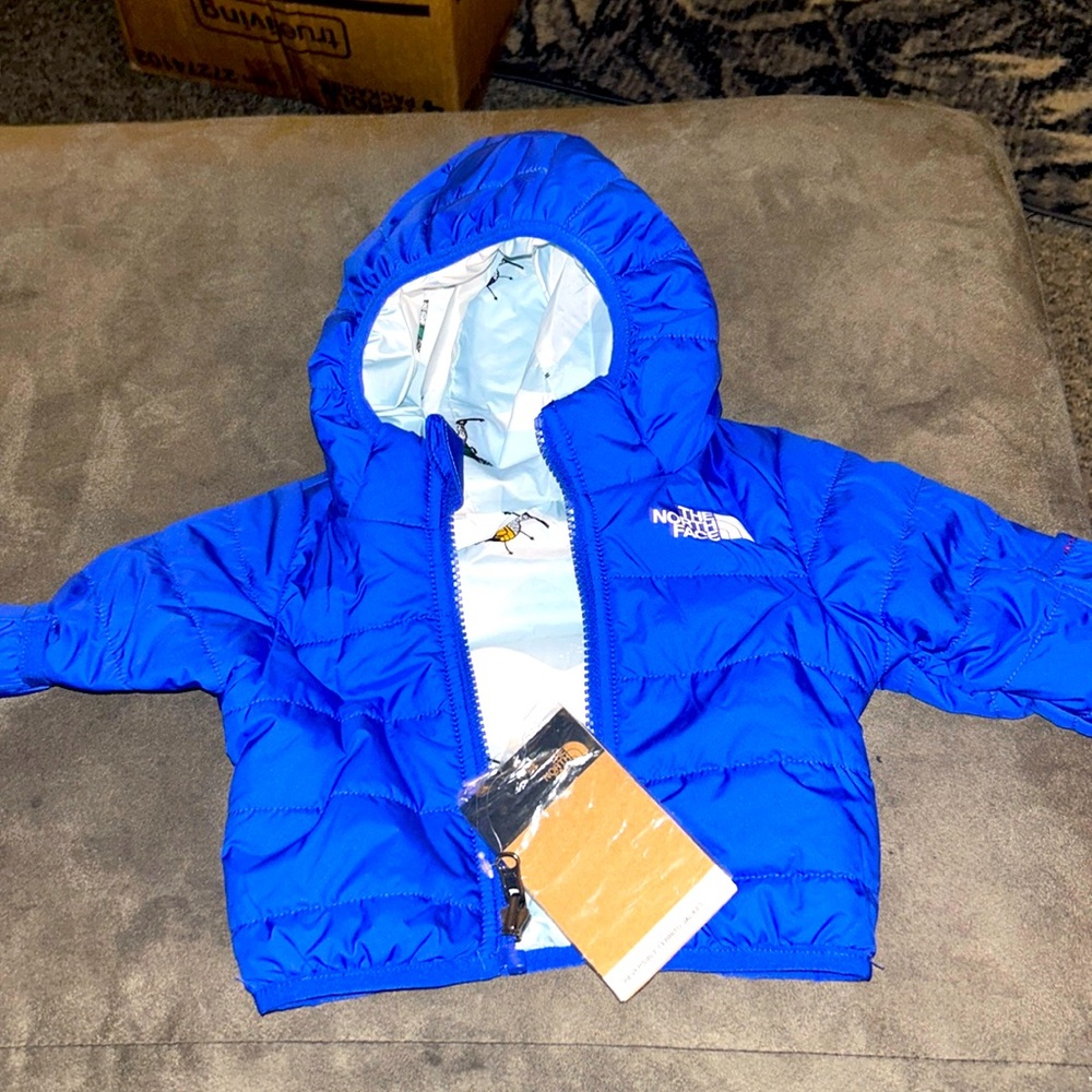 North Face puffer. Blue,new,reversible. Uggs/original box,0-3 months.